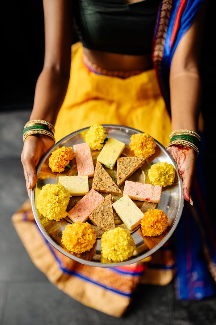 Person Holding Stainless Steel Plate of Traditional Desserts